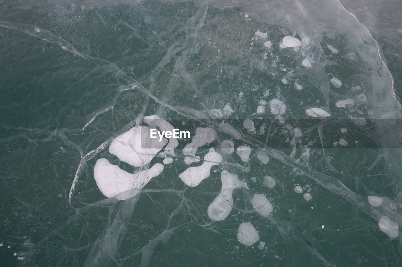 HIGH ANGLE VIEW OF LEAF FLOATING ON SNOW