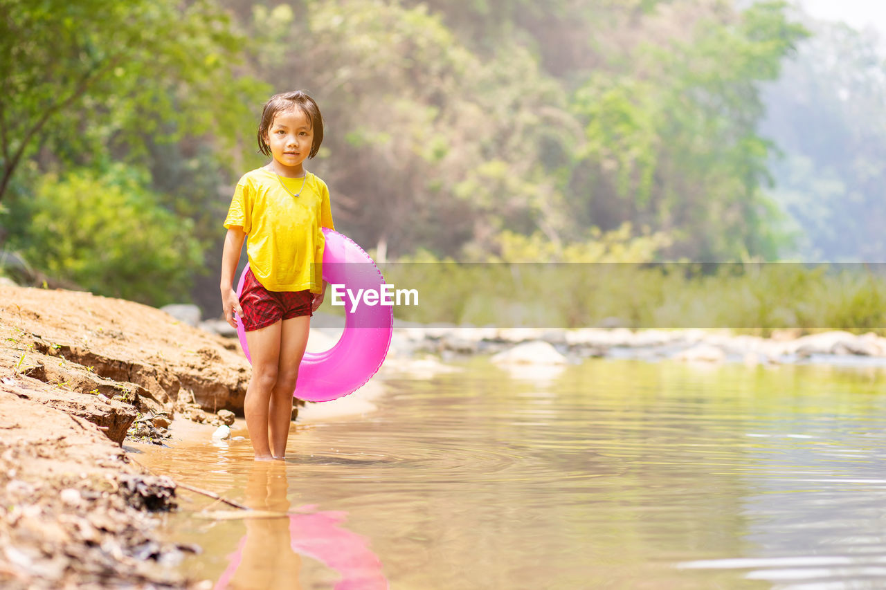 Portrait of smiling girl standing in lake