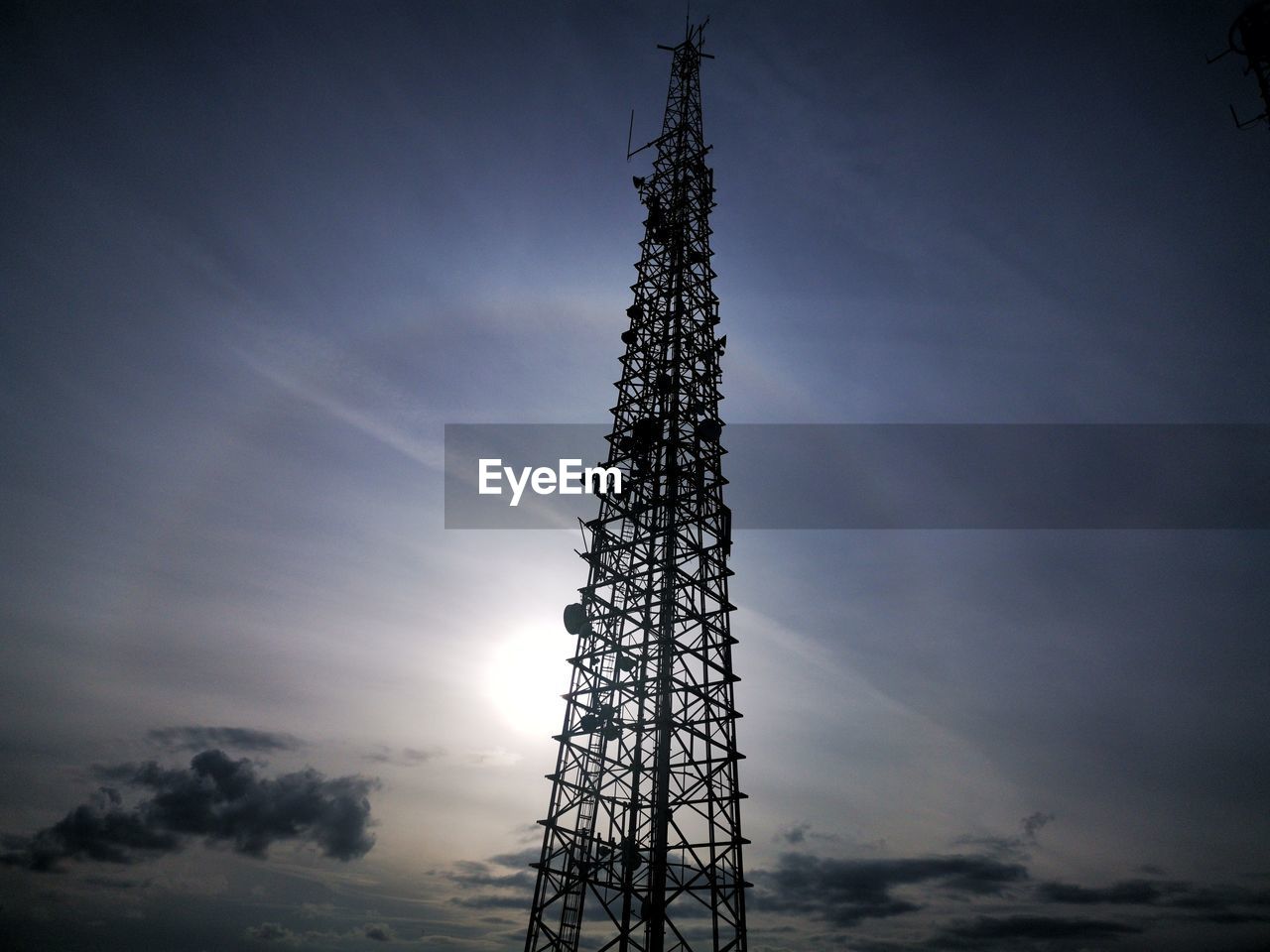 LOW ANGLE VIEW OF COMMUNICATIONS TOWER AGAINST SKY AT SUNSET
