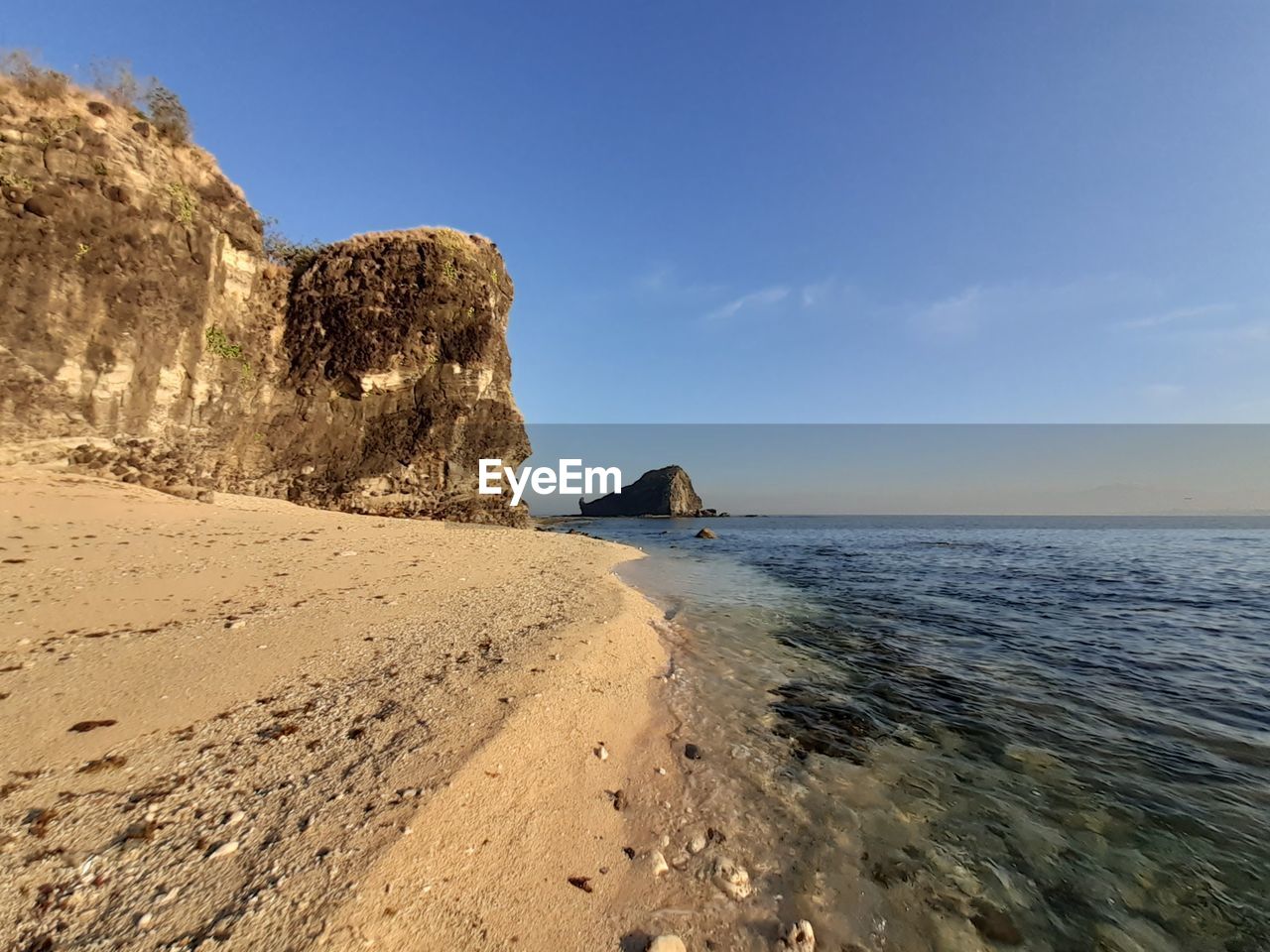 Rock formation on beach against sky