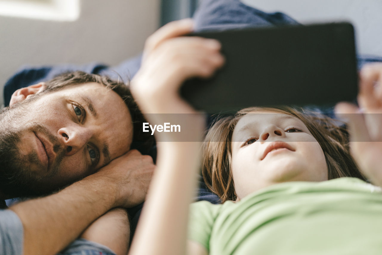 Father and son looking at smartphone together at home