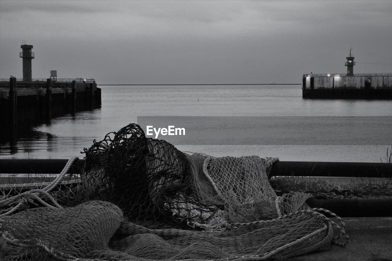 Black and white of pier against evening sky. gate to the open sea