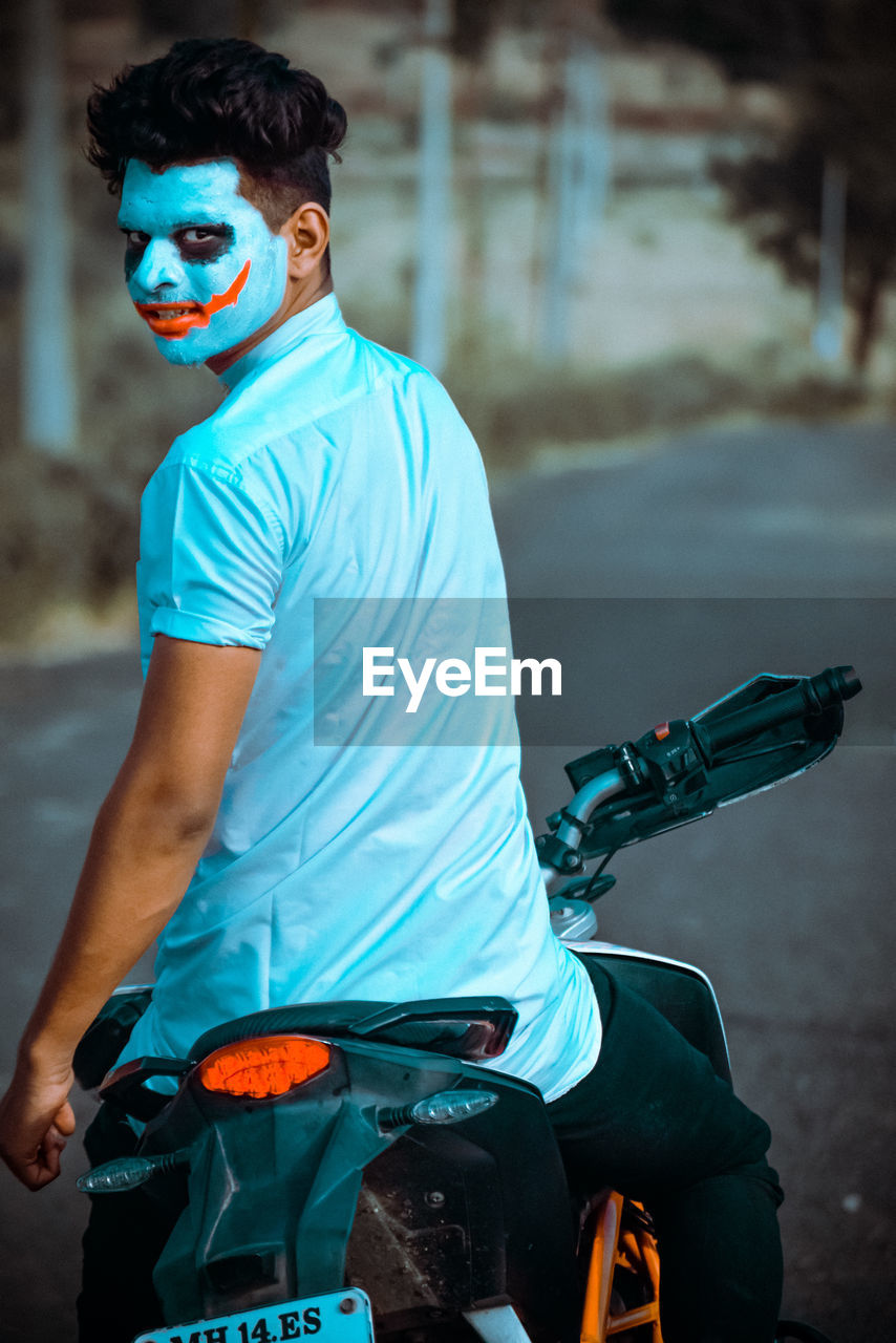 Portrait of man sitting on motorcycle at road