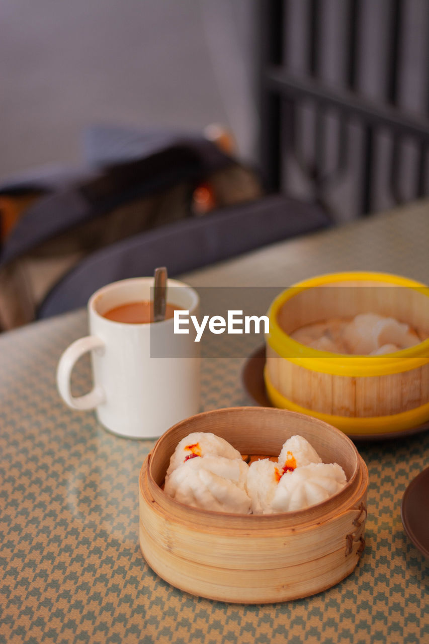 food and drink, food, dim sum, asian food, freshness, healthy eating, wellbeing, no people, cup, focus on foreground, drink, mug, meal, table, tea, chinese food, baked, indoors, dish, dumpling, tableware, breakfast, coffee cup, hot drink, still life, sweet food