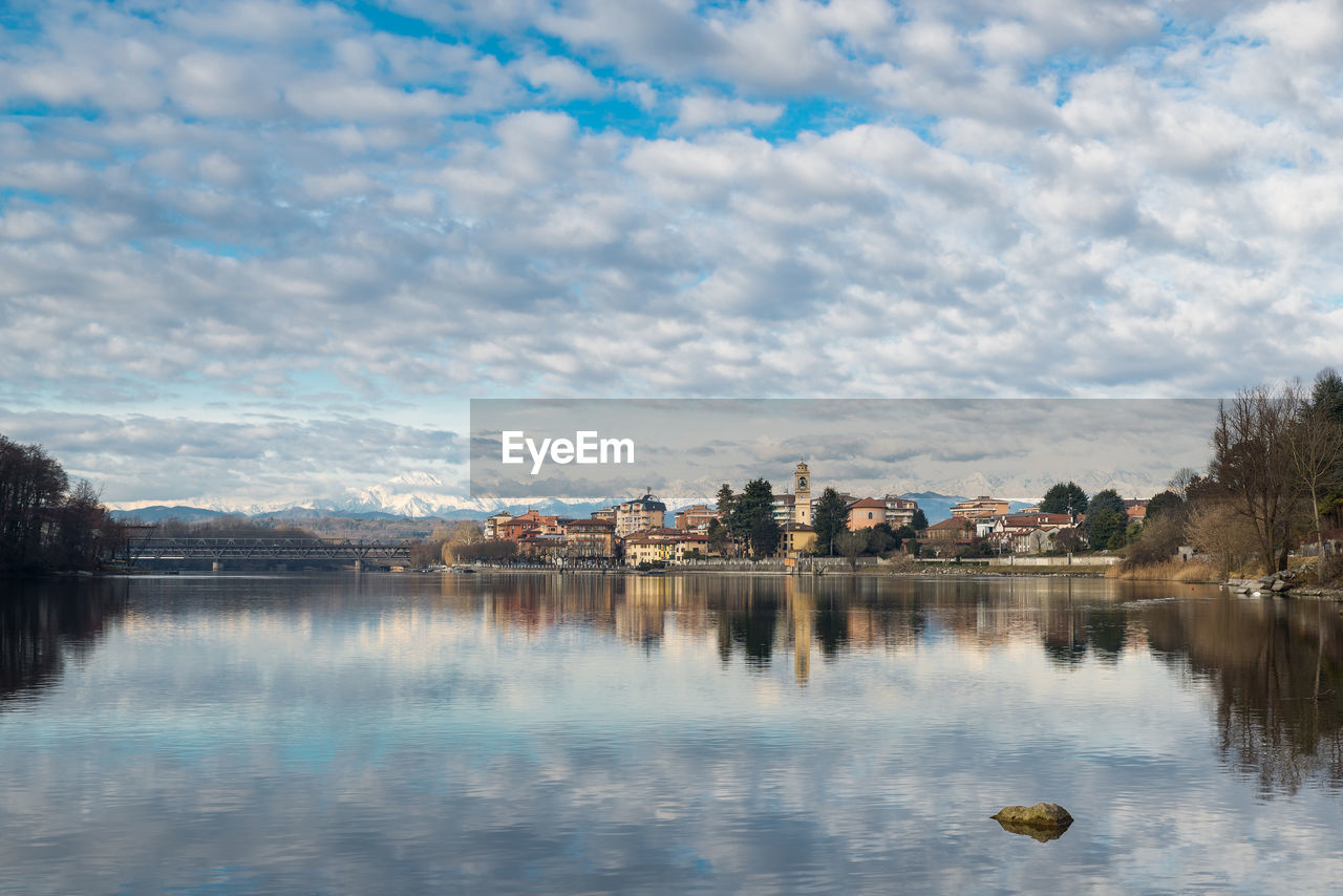 LAKE BY BUILDINGS AGAINST SKY