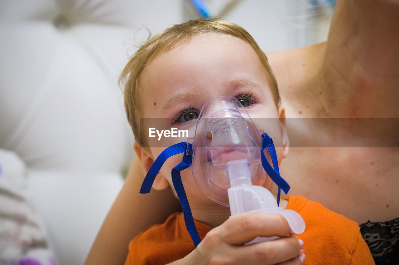 Close-up of baby wearing asthma inhaler