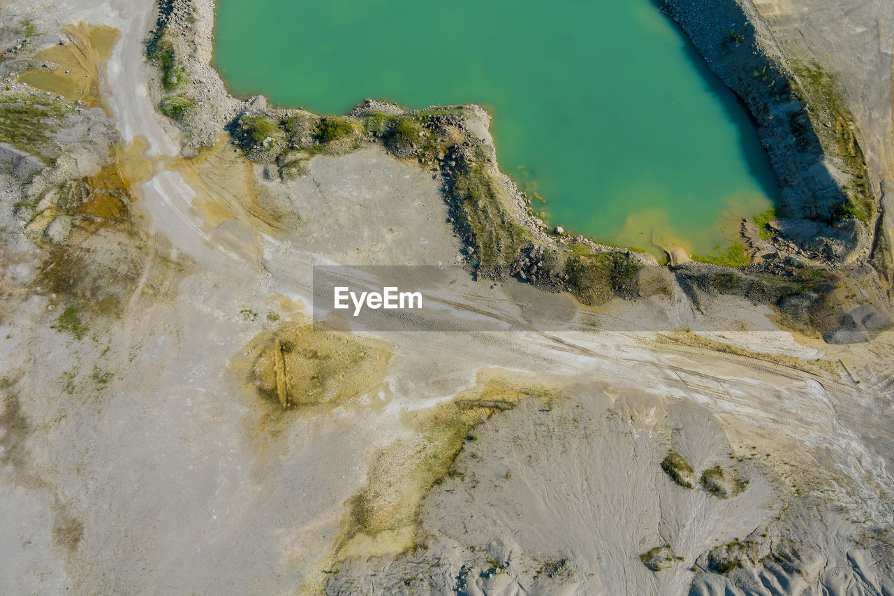 HIGH ANGLE VIEW OF ROCK FORMATIONS IN SEA