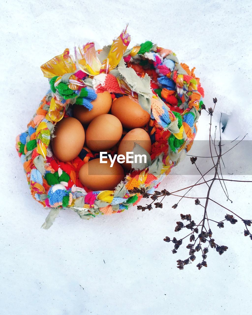 High angle view of eggs in rag basket on snow