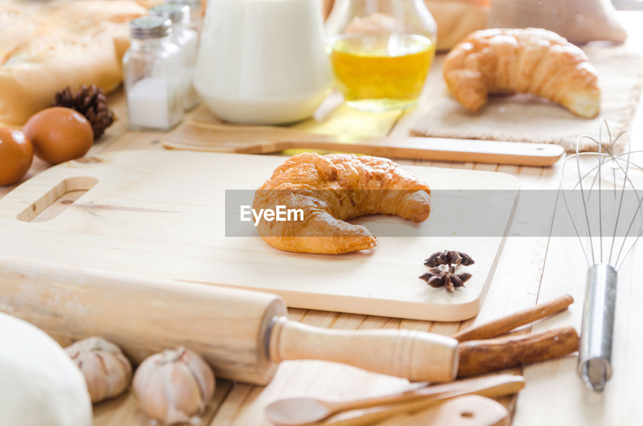 Close-up of croissant and ingredients on table