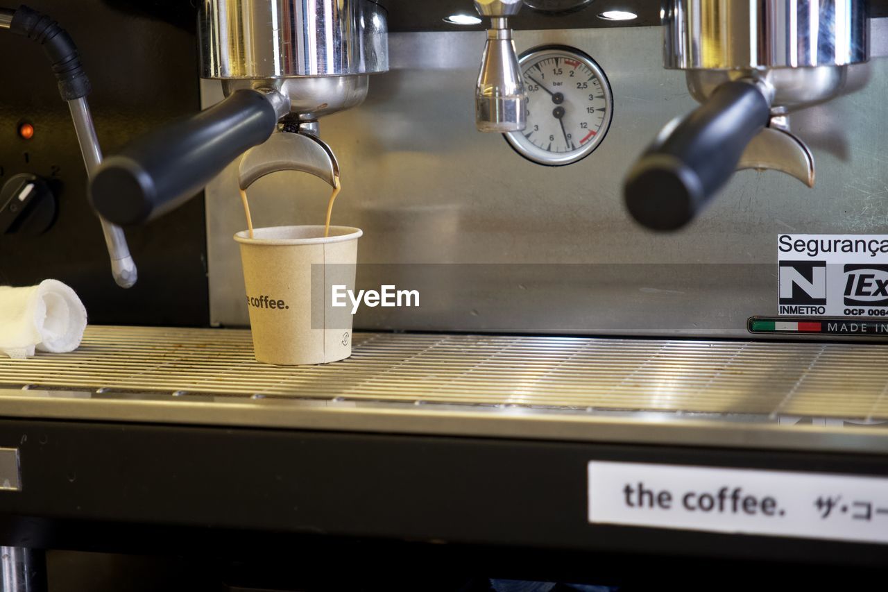 espresso machine, food and drink, indoors, coffee, coffeemaker, cup, drink, espresso maker, kitchen, mug, coffee cup, coffee shop, cafe, no people, appliance, small appliance, household equipment, refreshment, domestic room, room, kitchen utensil, domestic kitchen, business, clock, text, food