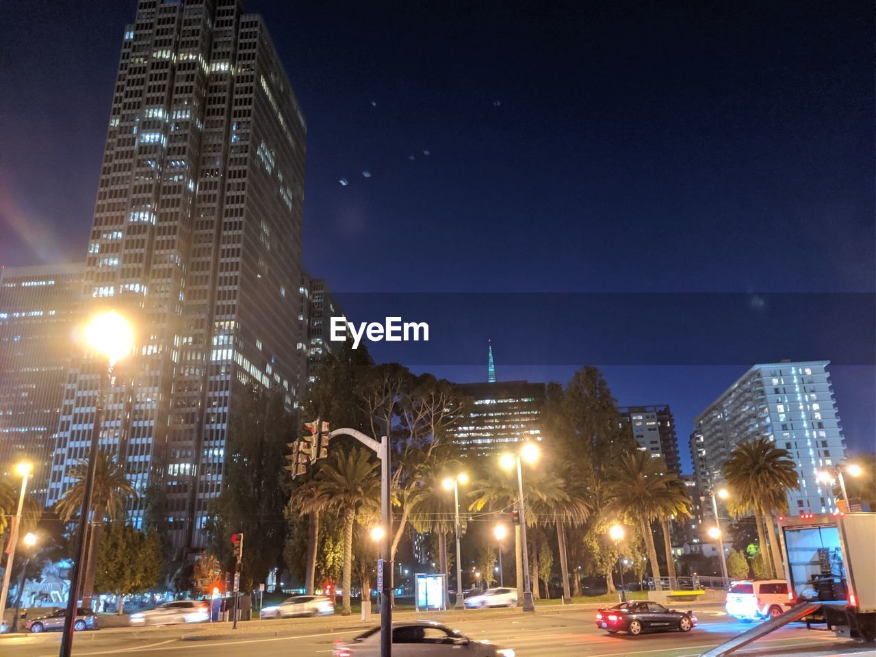 ILLUMINATED CITY STREET AND BUILDINGS AT NIGHT