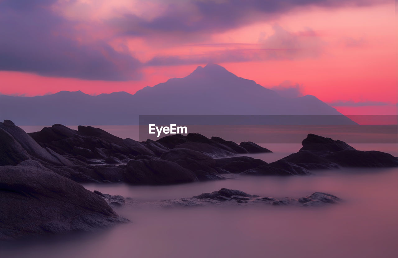 Scenic view of sea and mountains against sky during sunset