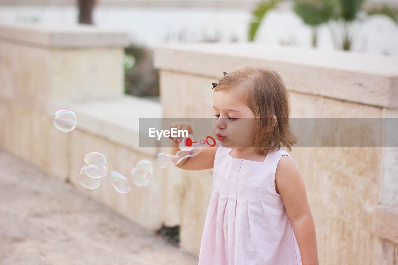 Girl blowing bubble from wand