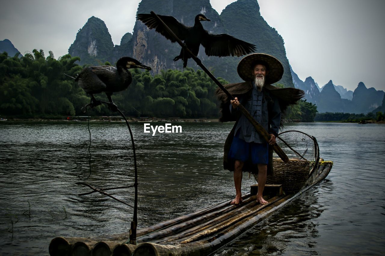 Chinese fisherman on traditional wooden raft