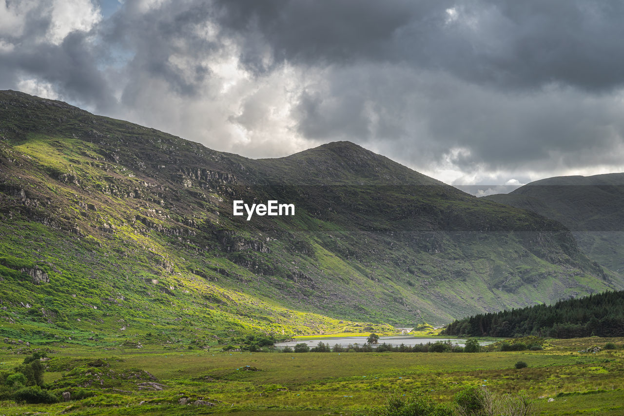 Small lake, lough gummeenduff in black valley, rocky hills of macgillycuddys reeks mountains ireland