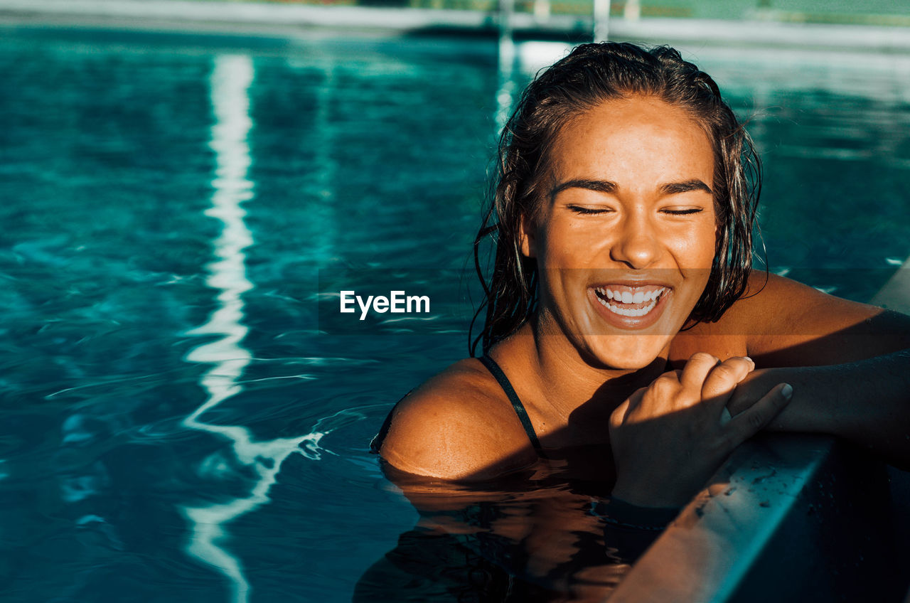 Beautiful smiling young woman in swimming pool