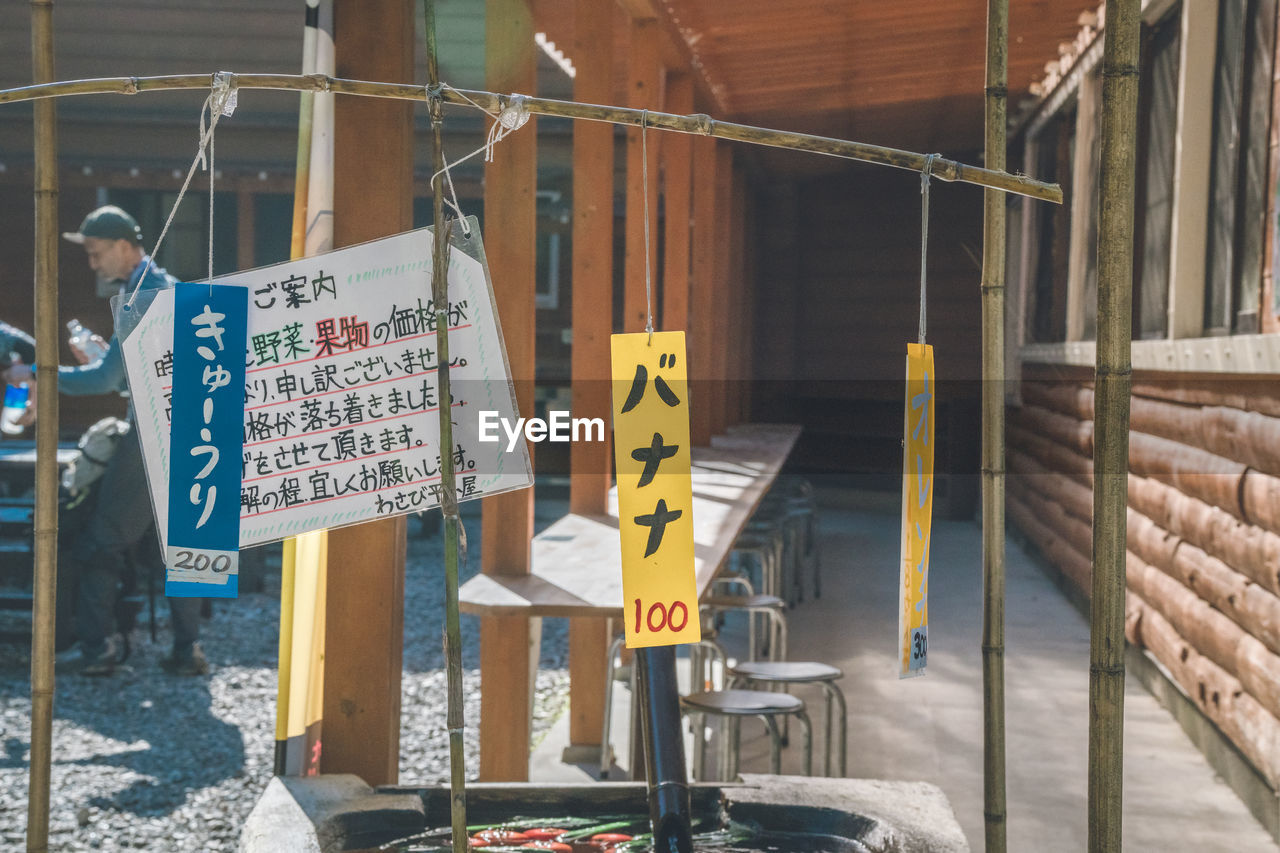 architecture, text, communication, sign, built structure, day, no people, building exterior, western script, city, outdoors, vehicle, hanging, urban area, street, script