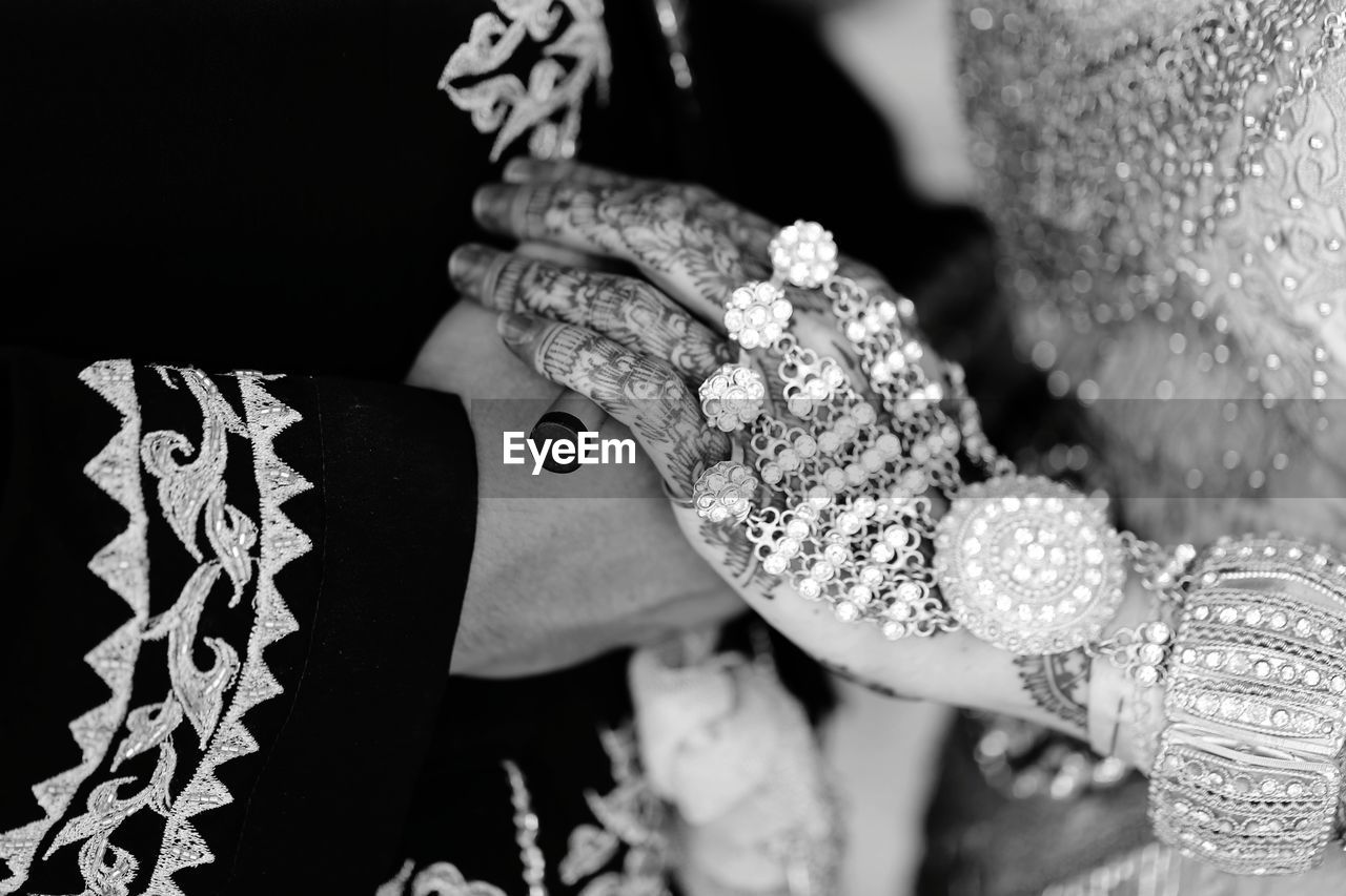 Midsection of bride holding wedding dress