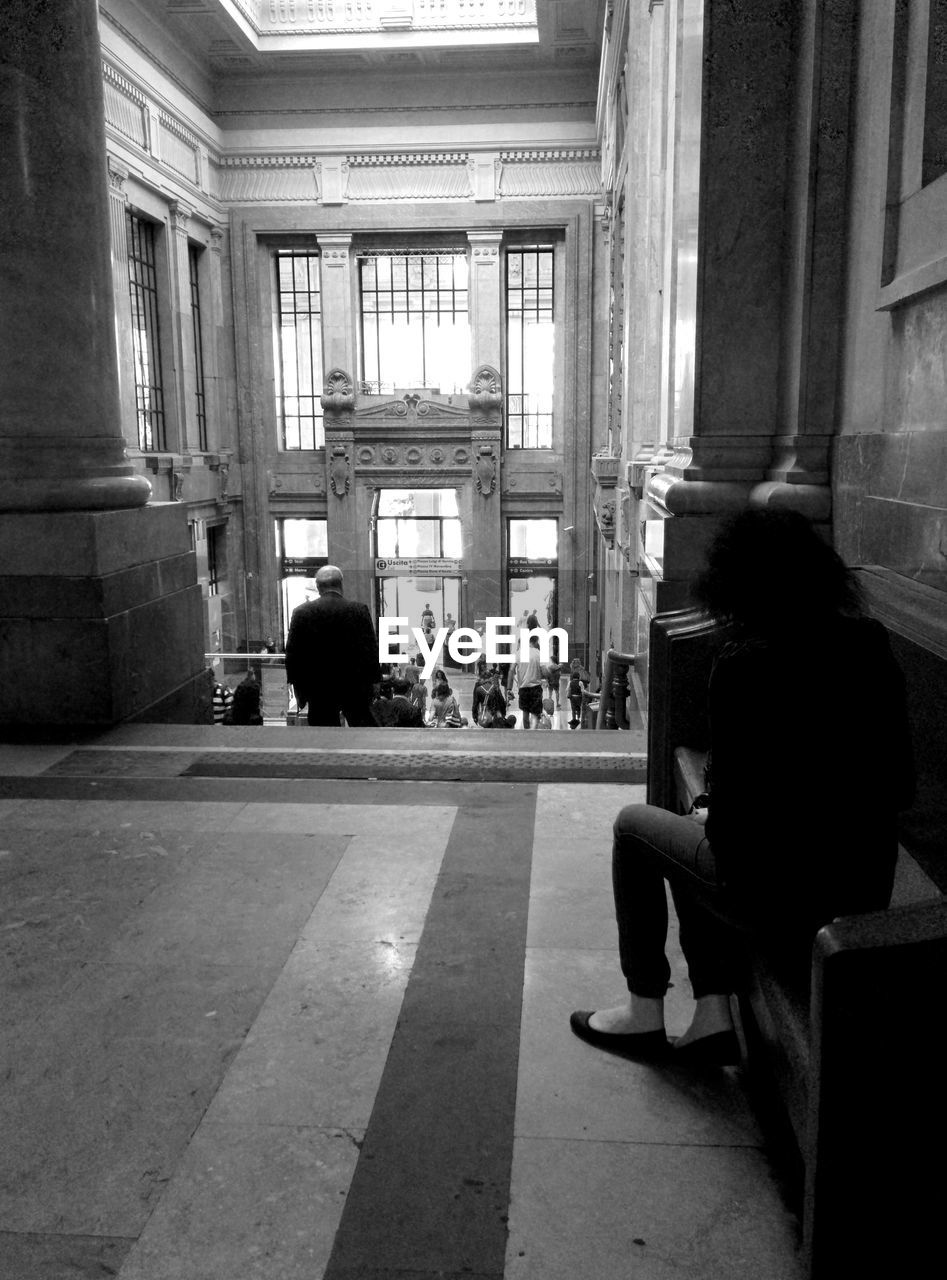 Woman sitting on marble bench in old fashioned building