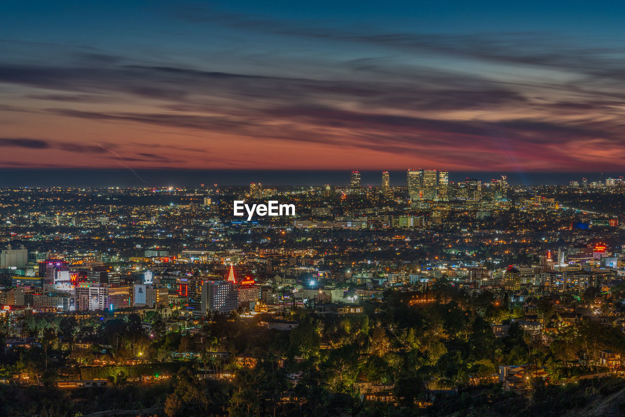 High angle view of illuminated cityscape against sky at night