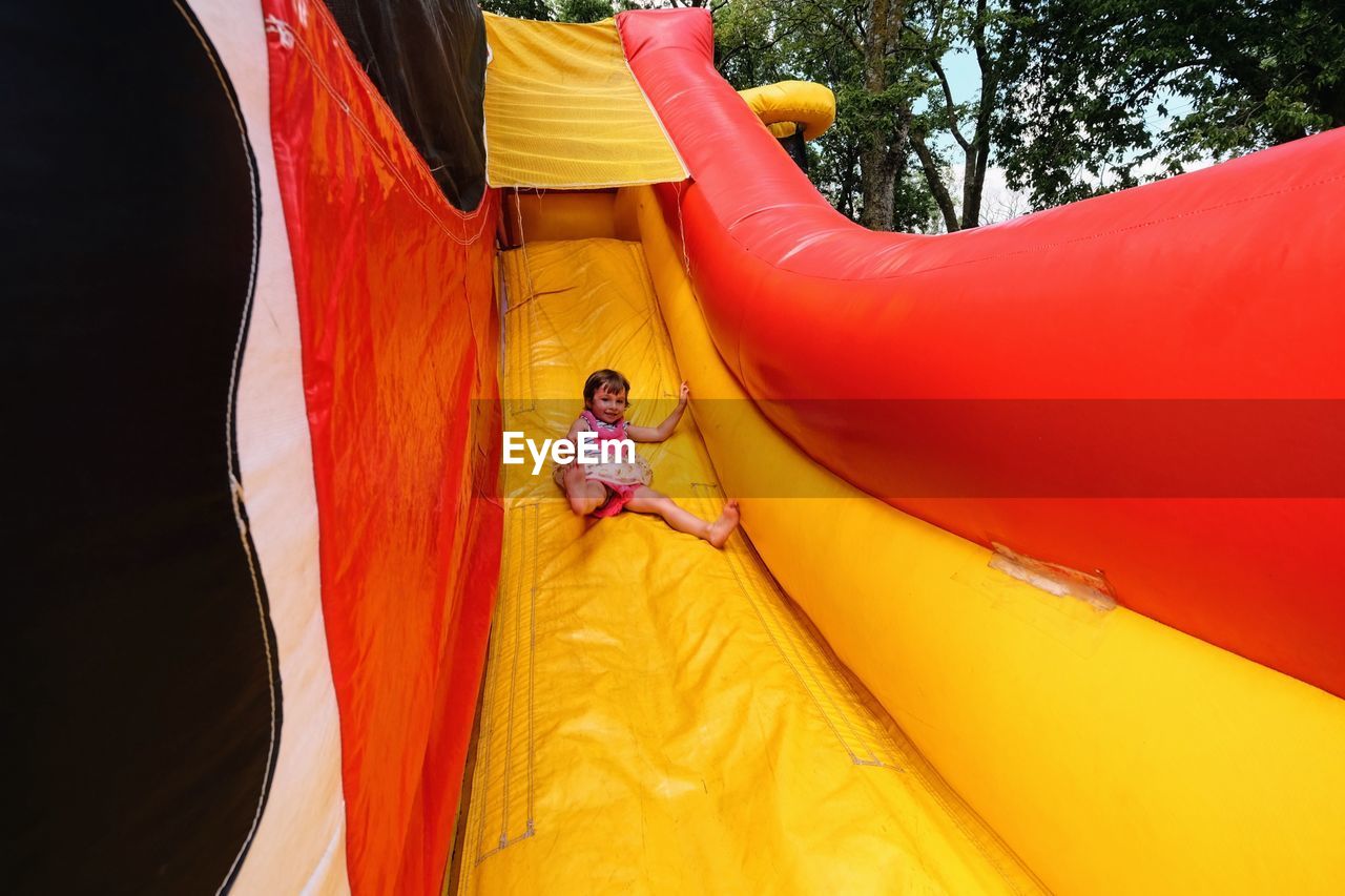 Full length of happy girl playing on bouncy castle