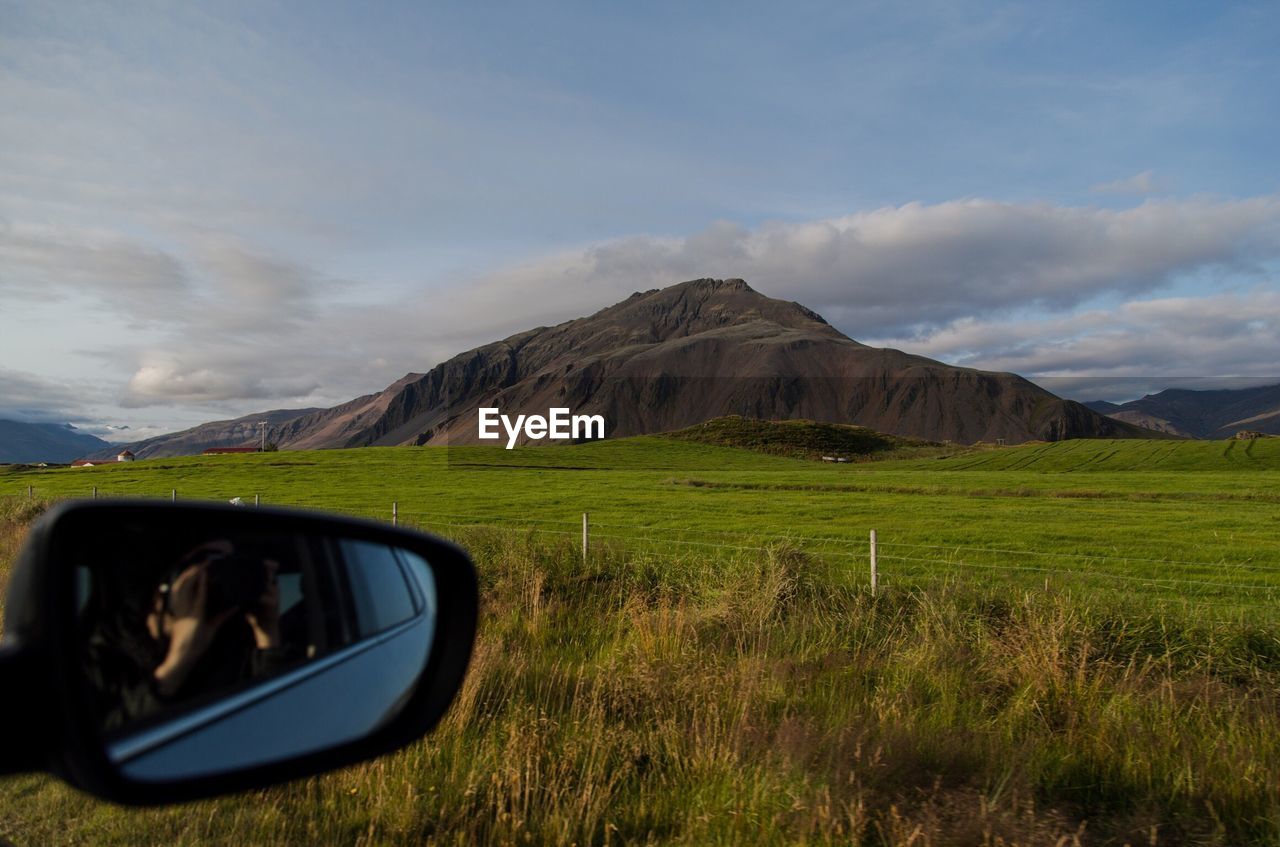 REFLECTION OF SIDE-VIEW MIRROR ON LANDSCAPE