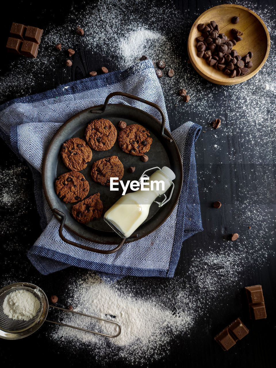 High angle view of cookies and milk in rustic tray  on table