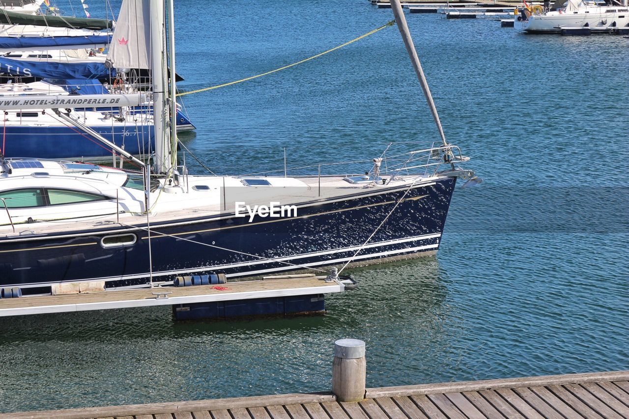 Sailboats moored at harbor