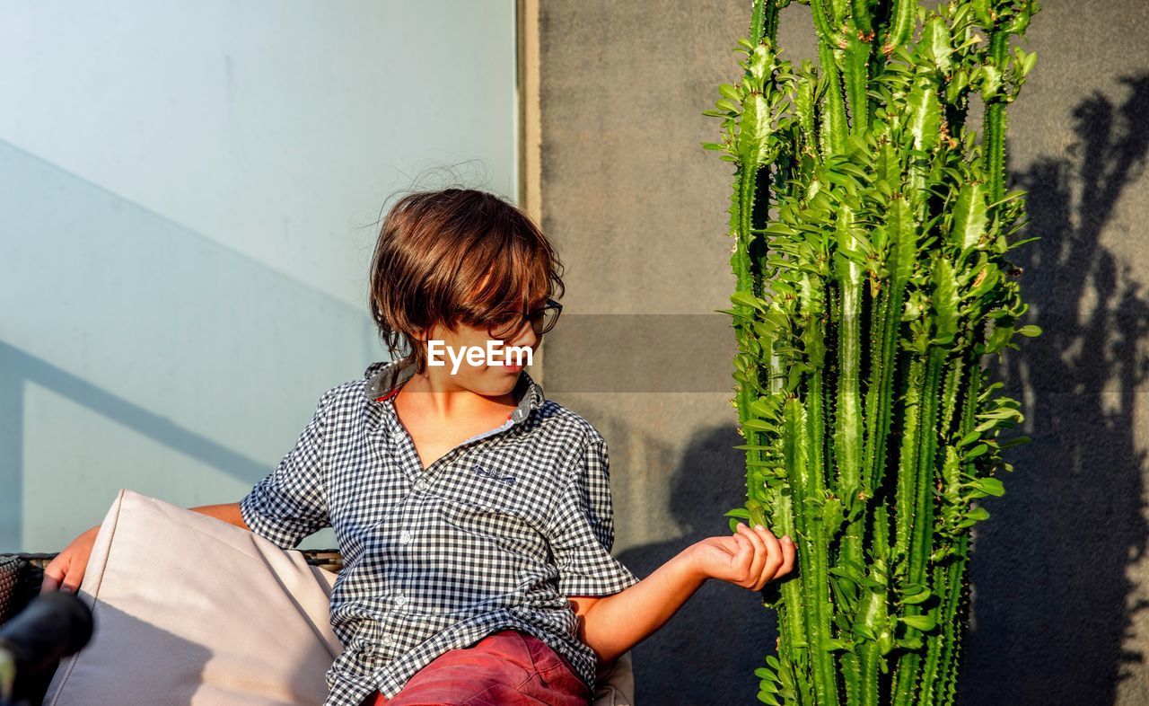 Rear view of boy against the cactus plant