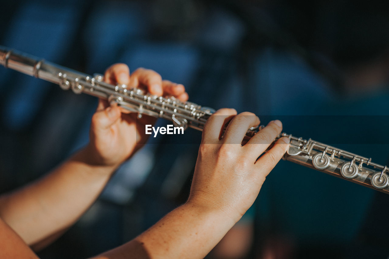 Close-up of hands playing the flute