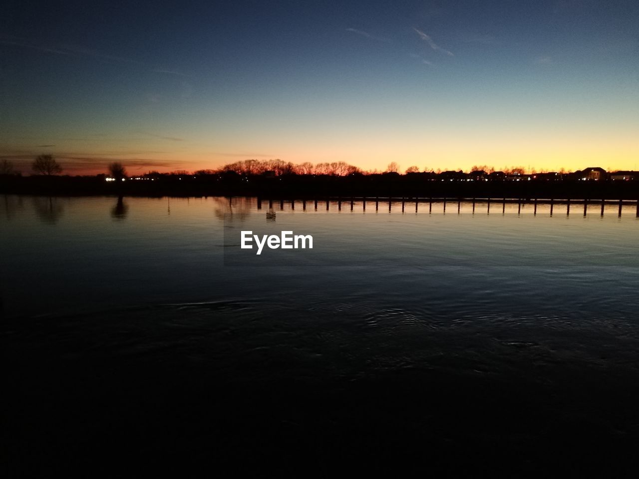 SCENIC VIEW OF LAKE BY SILHOUETTE TREES AGAINST SKY