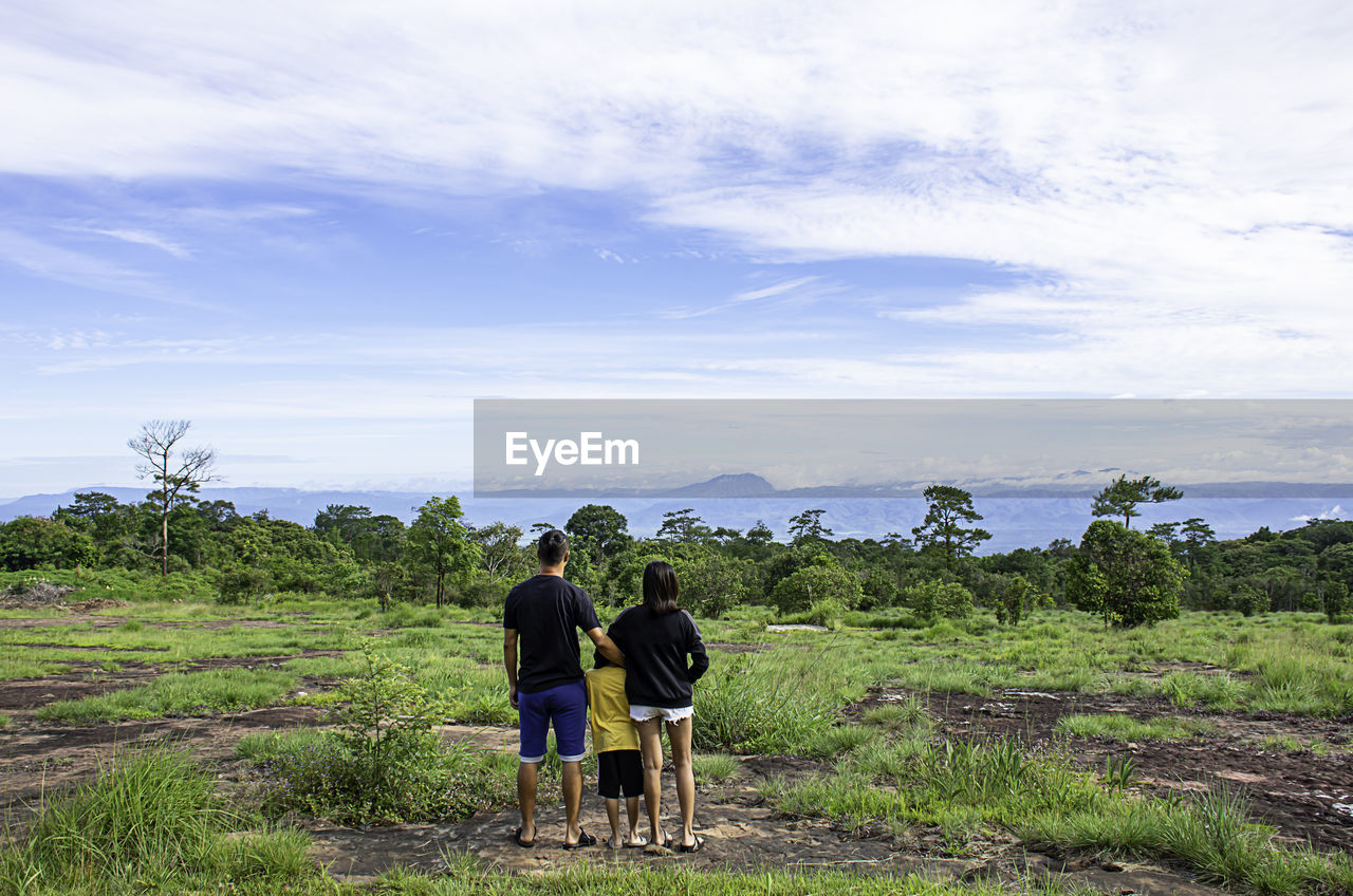 Rear view of people on landscape against sky