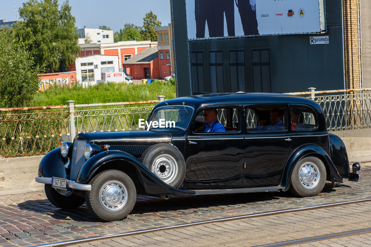 VINTAGE CAR ON STREET AGAINST BUILDING