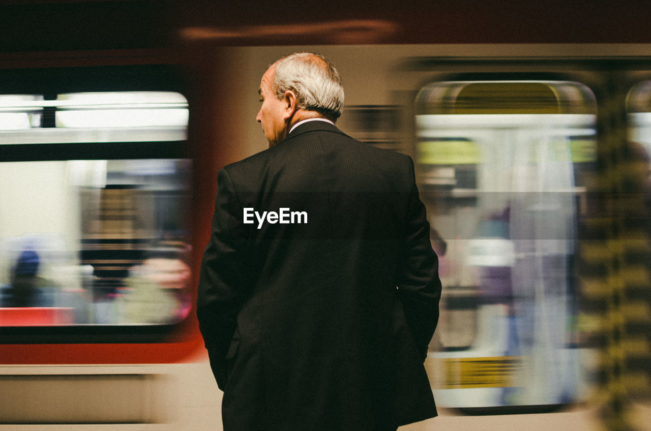 REAR VIEW OF MAN AT TRAIN