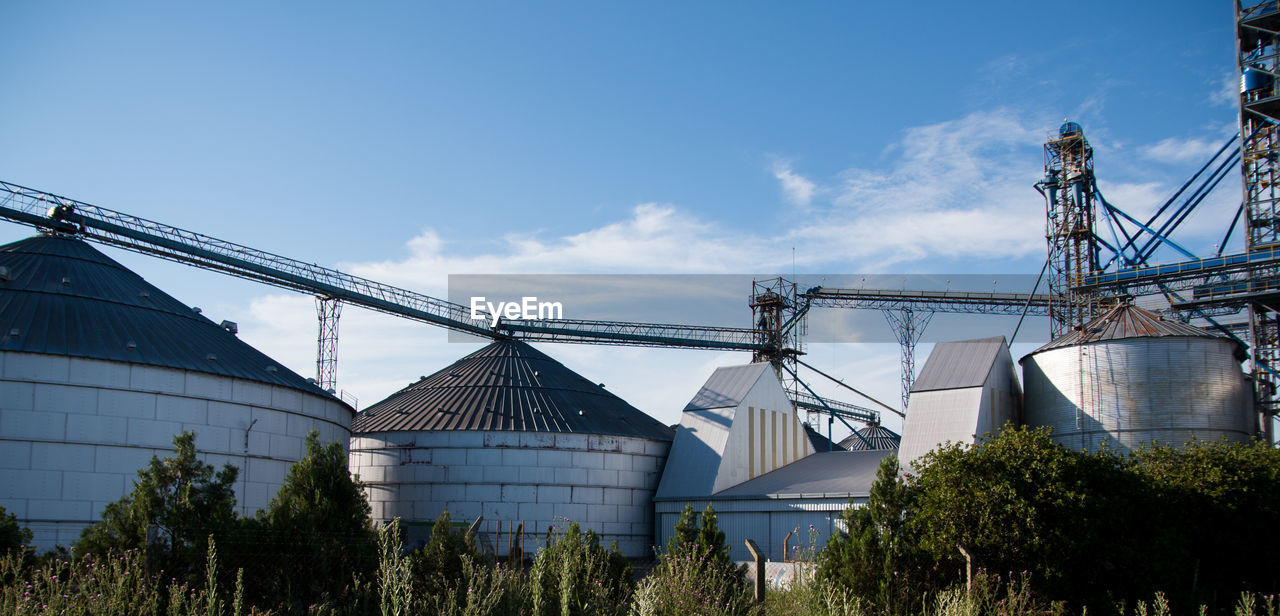 Low angle view of agricultural factory against sky