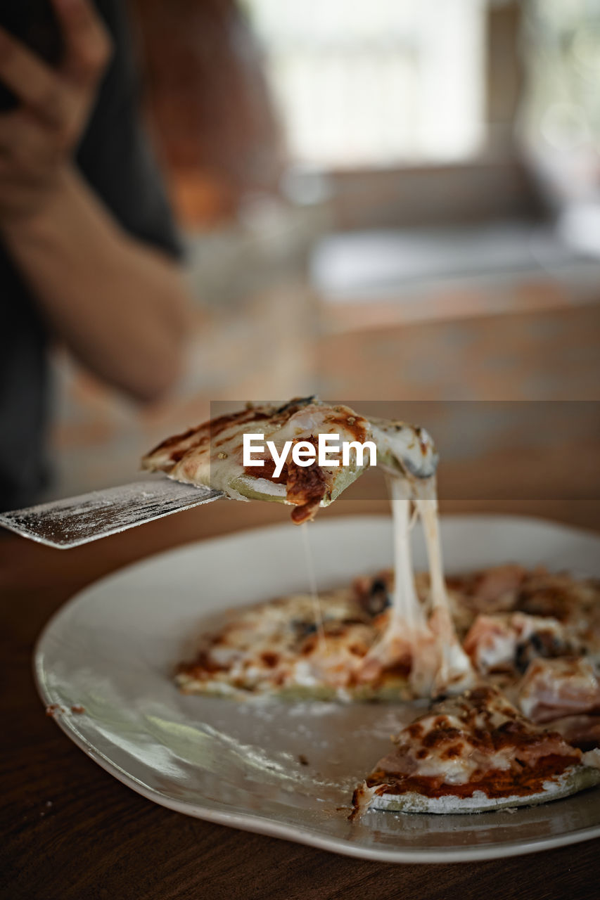 cropped hand of person preparing food on table