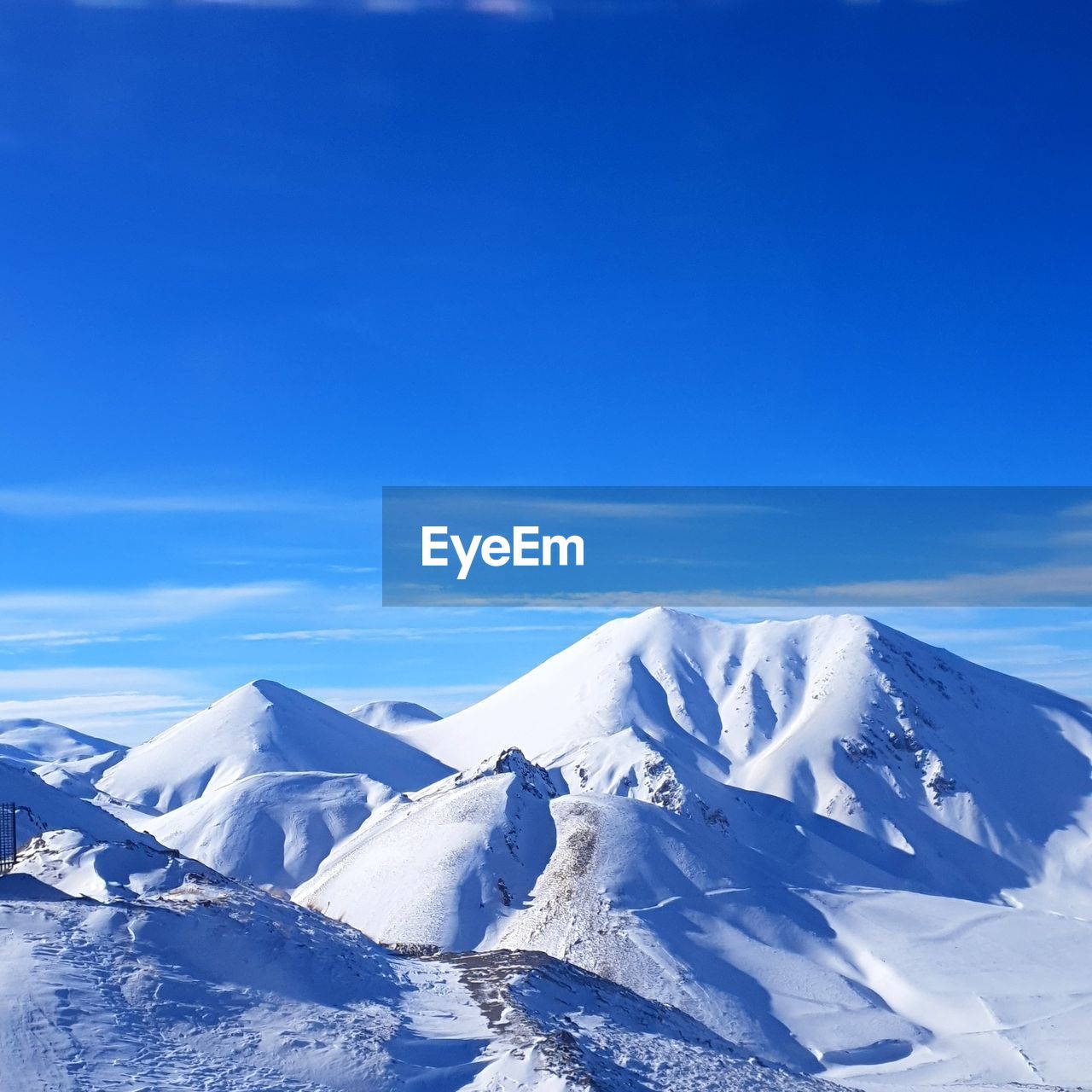 Scenic view of snowcapped mountains against blue sky