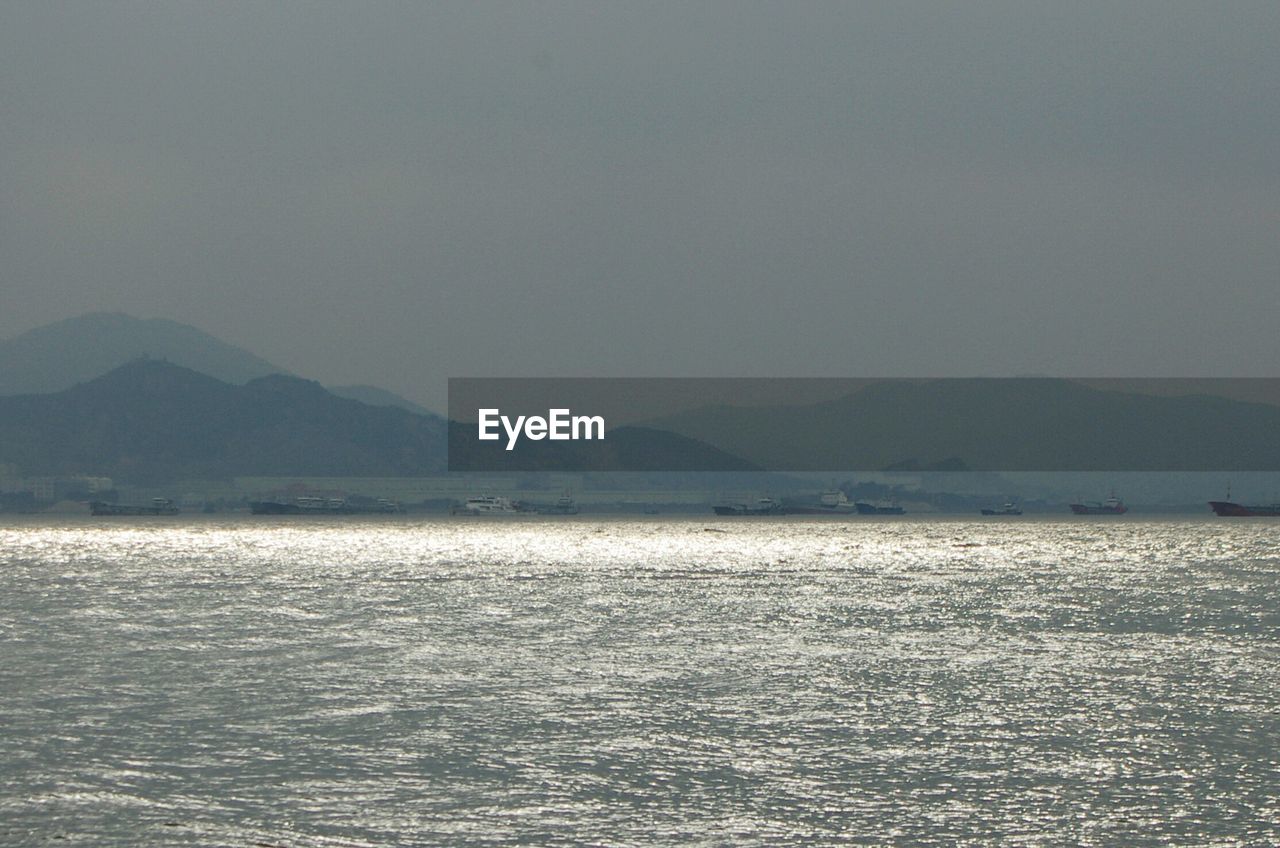 SCENIC VIEW OF SEA WITH MOUNTAINS IN BACKGROUND