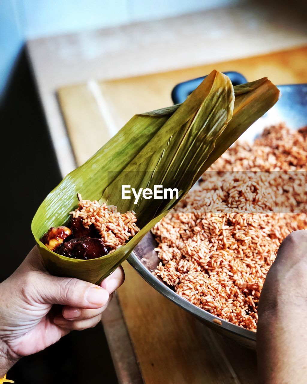 CLOSE-UP OF HAND HOLDING BOWL OF FOOD