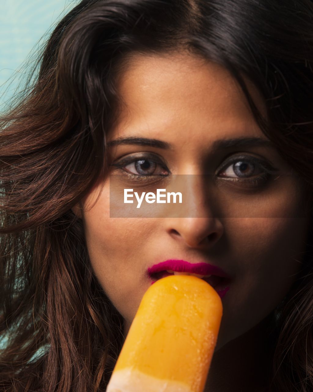 Close-up portrait of young woman eating popsicle