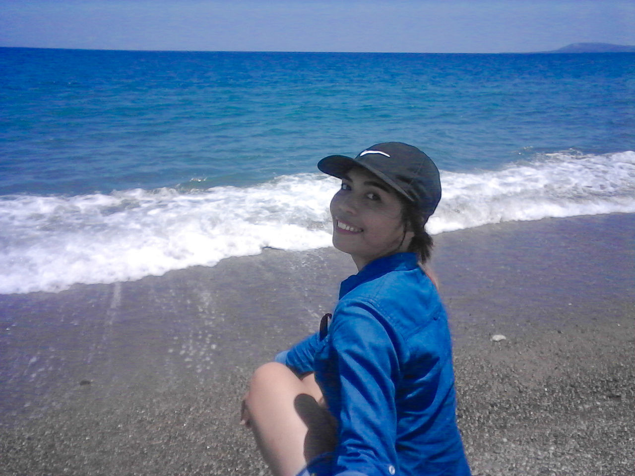 YOUNG WOMAN STANDING ON BEACH