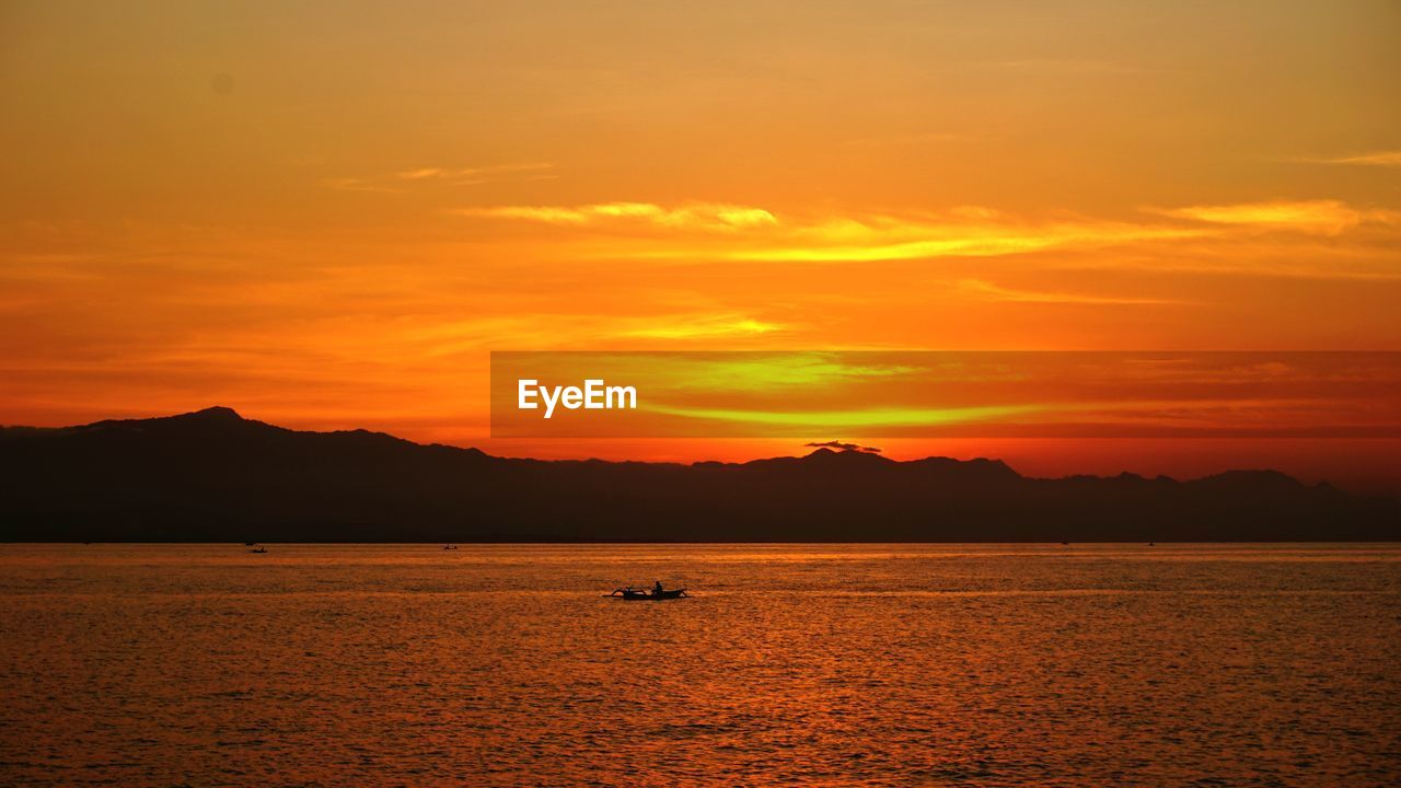 SCENIC VIEW OF SEA AGAINST SKY AT SUNSET