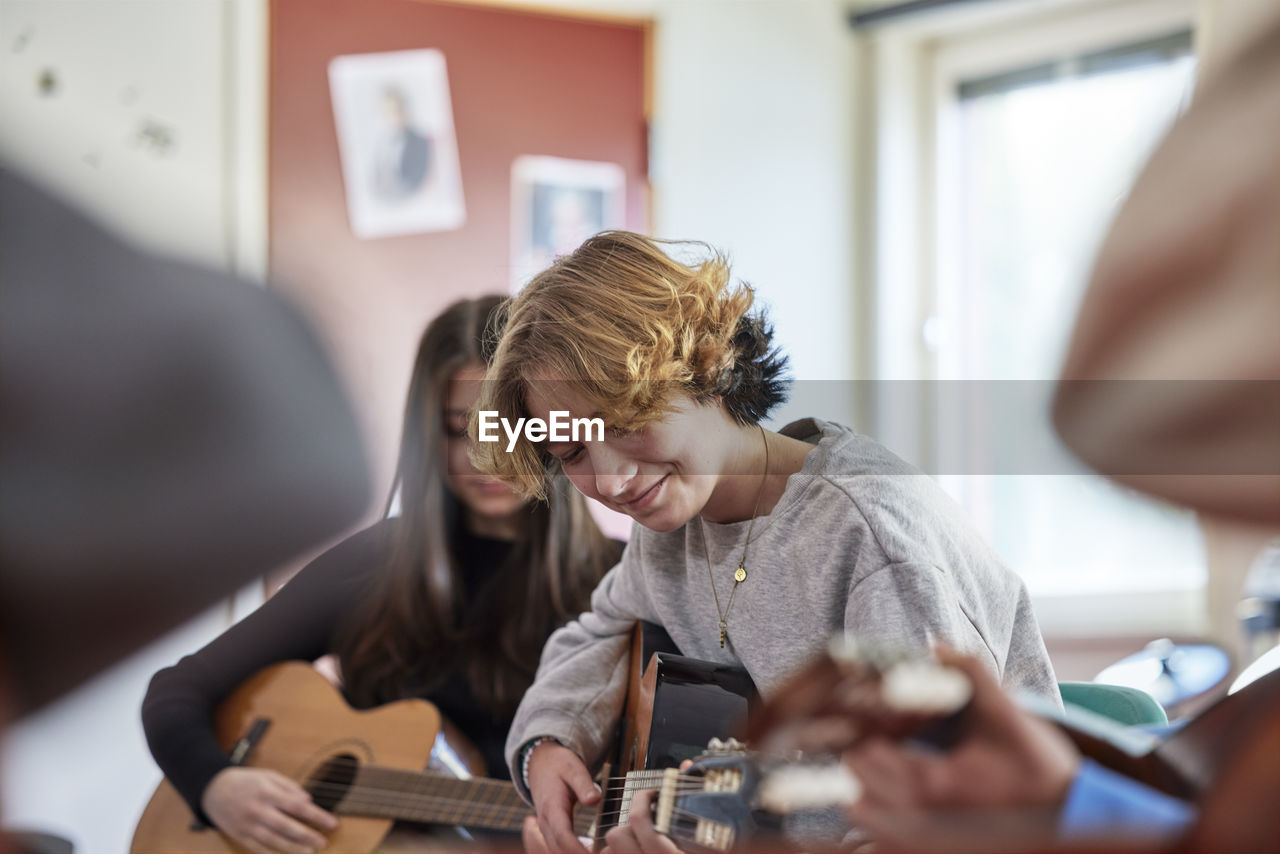 Teenagers attending guitar lesson