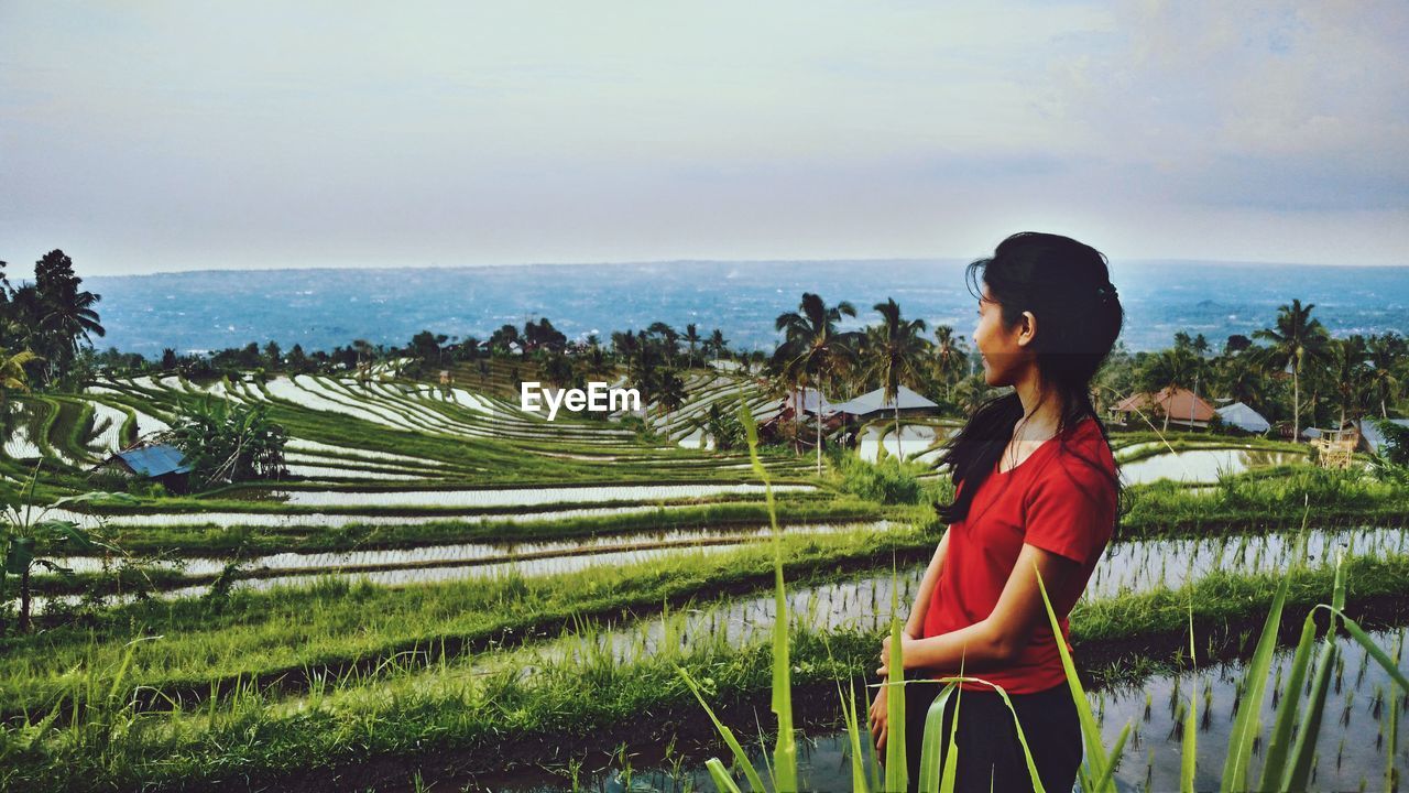 Woman standing on field against sky