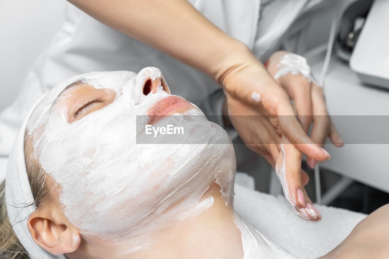 Midsection of woman relaxing on bed