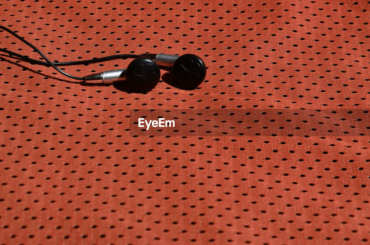 Close-up of in-ear headphones on textile