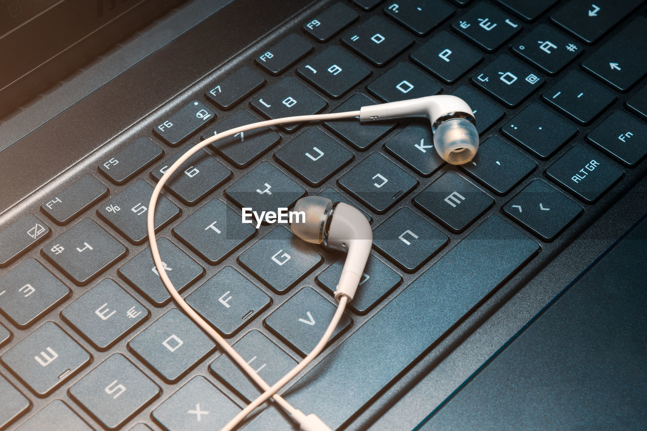 Close-up of in-ear headphones on laptop