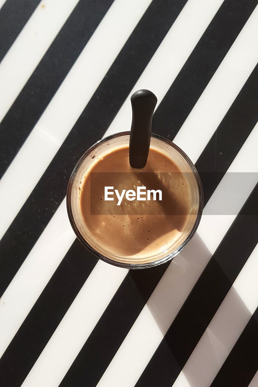 HIGH ANGLE VIEW OF COFFEE CUP ON GLASS