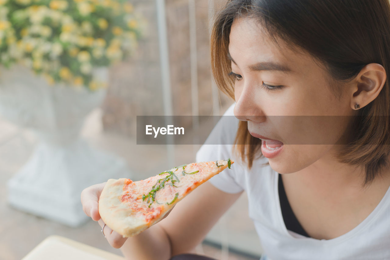 Close-up of woman eating pizza