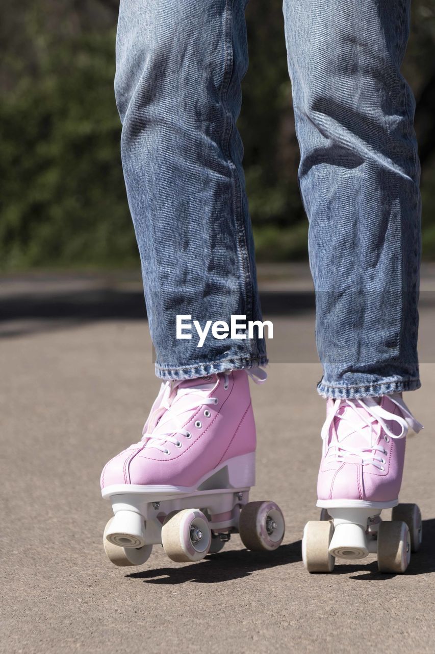 Woman skating in jeans and pink roller skates